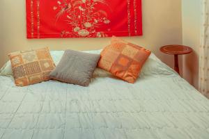 - un lit avec trois oreillers et un tableau mural dans l'établissement Corfu Espianada apartment, à Corfou