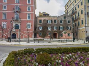 une rue dans une ville avec des bâtiments et des fleurs dans l'établissement Corfu Espianada apartment, à Corfou