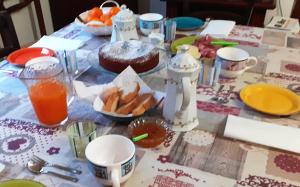 un tavolo con una tovaglia, cibo e succo d'arancia di B/B Casa Angela a Firenzuola