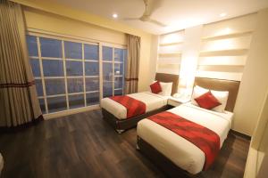 um quarto de hotel com duas camas e uma janela em Hotel Picasso Prive Naraina Delhi - Couple Friendly Local IDs Accepted em Nova Deli
