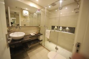uma casa de banho com um lavatório e uma cabina de duche em vidro. em Hotel Picasso Prive Naraina Delhi - Couple Friendly Local IDs Accepted em Nova Deli