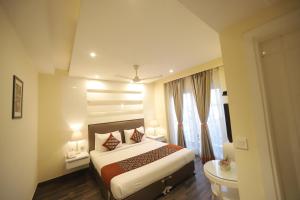 a hotel room with a bed and a window at Hotel Picasso Prive Naraina Delhi - Couple Friendly Local IDs Accepted in New Delhi