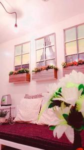 een slaapkamer met 3 ramen en een bed met bloemen bij French Nest at Baguio- Megatower Residences in Baguio