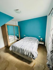 Japi Duplex في لوسينا: غرفة نوم بسرير مع جدار ازرق