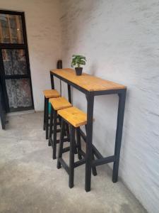 einen Tisch und vier Hocker mit einer Topfpflanze darauf in der Unterkunft Relax In Maboneng in Johannesburg