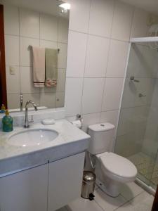 ein Badezimmer mit Toilette, Waschbecken und Dusche in der Unterkunft Paraíso dos corais Pe na areia in Guarajuba