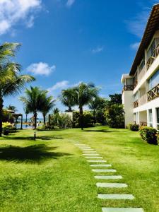 einen Pfad im Gras neben einem Gebäude in der Unterkunft Paraíso dos corais Pe na areia in Guarajuba