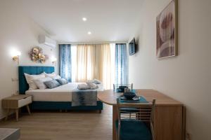 1 dormitorio con 1 cama y 1 mesa en una habitación en Kalypso Apartments, en Kalamata