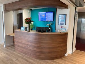 an office with a reception counter with a blue wall at Kyriad Dol-de-Bretagne in Dol-de-Bretagne