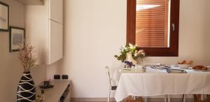 ラ・マッダレーナにあるCala Gavetta Marina Loftのキッチンに白いテーブルクロス付きテーブル