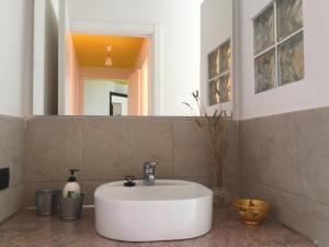 Un baño con un lavabo blanco y un espejo. en Cala Gavetta Marina Loft, en La Maddalena 45 fotos más