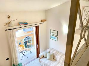 sala de estar con sofá blanco y puerta corredera de cristal en Cala Gavetta Marina Loft, en La Maddalena