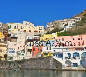 a group of buildings on a hill next to the water at La Casa Azzurra in Procida