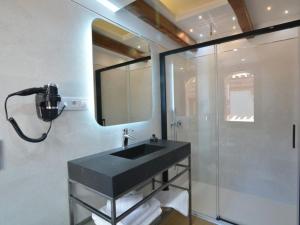 a bathroom with a black sink and a shower at Hospedium Hotel Posada de la Silleria in Toledo