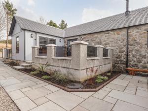 a stone house with a patio in front of it at The Steading in Rogart