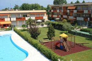 a hotel with a playground next to a swimming pool at Gardappartamenti Benacus Sirmione in Sirmione
