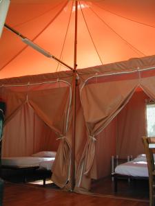 une tente orange avec 2 lits dans l'établissement Camping Paduella, à Calvi