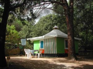 une tente avec une table et des chaises devant elle dans l'établissement Camping Paduella, à Calvi