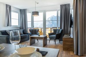 a living room with a couch and a table at AlpenParks Hotel & Apartment Alpendorf in Sankt Johann im Pongau