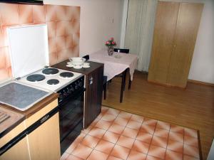 a kitchen with a stove and a table with a tableablish at Apartments Vidović in Vodice +42 photos