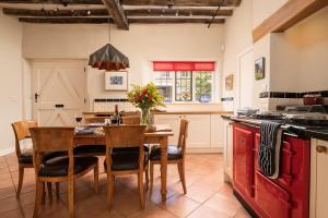 a kitchen with a wooden table with chairs and a kitchen counters at The Stables in Kings Cliffe