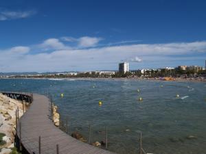 a view of a beach with a boardwalk in the water at Apartment Duplex Iberia by Interhome in Salou