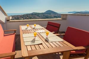 una mesa de madera con cuatro vasos de zumo de naranja. en Apartment Sun & Sky, en Dubrovnik