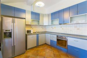 una cocina con armarios azules y electrodomésticos de acero inoxidable en Apartment Sun & Sky, en Dubrovnik