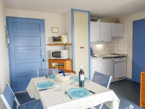 une cuisine avec une table et une porte bleue dans l'établissement Apartment Gruissan Plage by Interhome, à Gruissan 26 autres photos