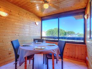 a dining room with a table and chairs and a window at Apartment Les Mas de La Mer-3 by Interhome in Saint-Cyprien-Plage