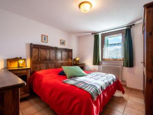 a bedroom with a red bed and a window at Apartment Grand Sarriod-5 by Interhome in Saint Nicolas