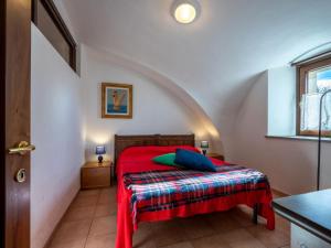 um quarto com uma cama vermelha e um cobertor vermelho em Apartment Grand Sarriod-1 by Interhome em Saint Nicolas