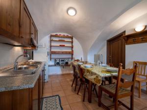 uma cozinha com uma mesa e cadeiras numa cozinha em Apartment Grand Sarriod-1 by Interhome em Saint Nicolas