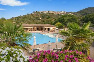 a resort with a swimming pool and a mountain at OasiMaremma Village in Scarlino