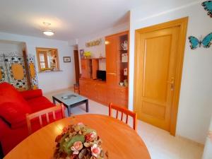 een woonkamer met een tafel en een rode bank bij ACV - Costa Marina I-1ª linea planta 9 Sur in El Borseral