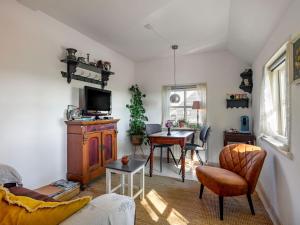 Zuid-Beijerland的住宿－圖澤特度假屋，客厅配有电视和桌椅