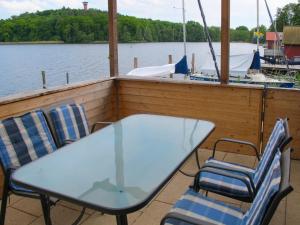 a table and chairs on the deck of a boat at Chalet Güstrower Chaussee by Interhome in Krakow am See