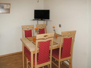 a dining room table with four chairs and a television at Holiday Home Goetheallee by Interhome in Krakow am See