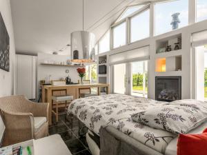 a bedroom with a bed and a dining room with a fireplace at Chalet De Orangerie by Interhome in Zaamslag +14 photos