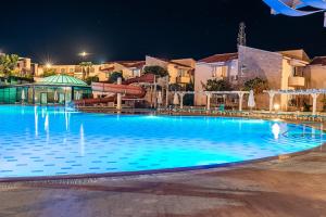 a large swimming pool at night with a water slide at Assos Dove Hotel Resort & SPA in Behramkale