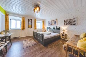 ein Schlafzimmer mit einem Bett, einer Couch und einem Tisch in der Unterkunft Berggasthof Hotel Duftbräu I Ruhige Alleinlage I Mitten im Grünen in Samerberg