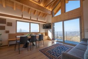 a living room with a table and chairs and large windows at Casera Cal De Mez- Wellness Chalet 