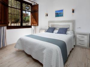 Balcon del MarにあるHoliday Home Cala Vista by Interhomeのベッドルーム(青い枕の大きな白いベッド付)