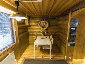 ユッラスヤルヴィにあるHoliday Home Rapula by Interhomeの小さな客室で、ログキャビンに白いテーブルが備わります。