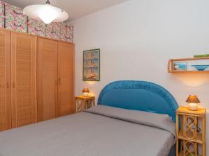 a bedroom with a blue bed and wooden cabinets at Apartment Casa Casu by Interhome in Solanas