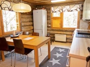 een keuken en eetkamer met een tafel en een koelkast bij Holiday Home Rukaveska 4a by Interhome in Ruka