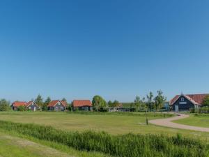 a view of a golf course with houses in the background at Holiday Home Zeeuwse Cottage Wemeldinge-1 by Interhome in Wemeldinge