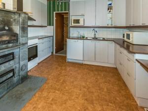 a large kitchen with white cabinets and a wooden floor at Holiday Home Kylämattila by Interhome in Ilola