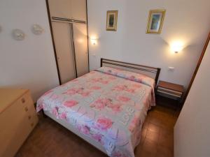 ビビオーネにあるApartment Simma-9 by Interhomeのピンクの花が飾られたベッド付きの小さなベッドルーム1室が備わります。