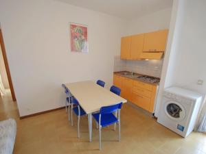 una piccola cucina con tavolo, sedie e lavatrice di Apartment Simma-9 by Interhome a Bibione